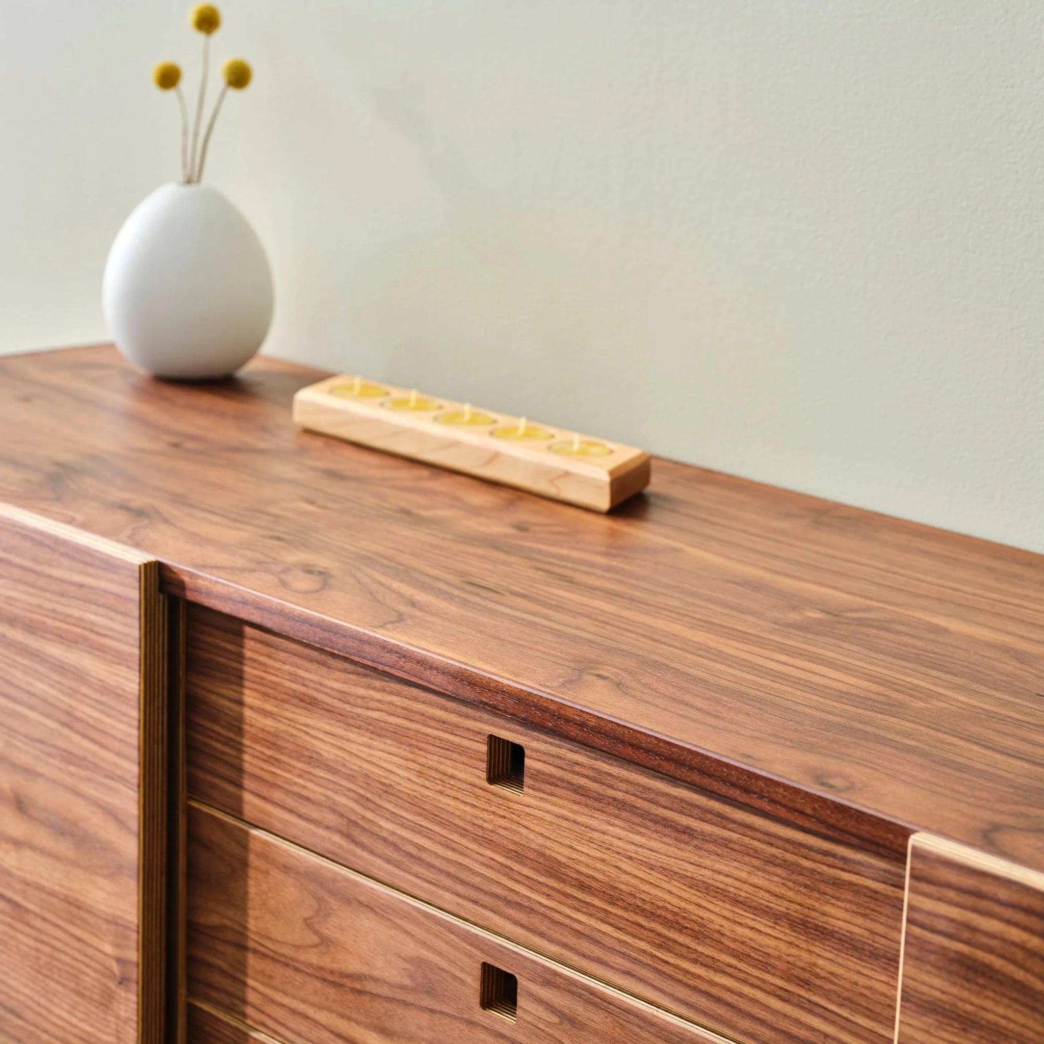 Walnut Media Console No. 2 top detail, square recessed drawer pulls, white vase and candle