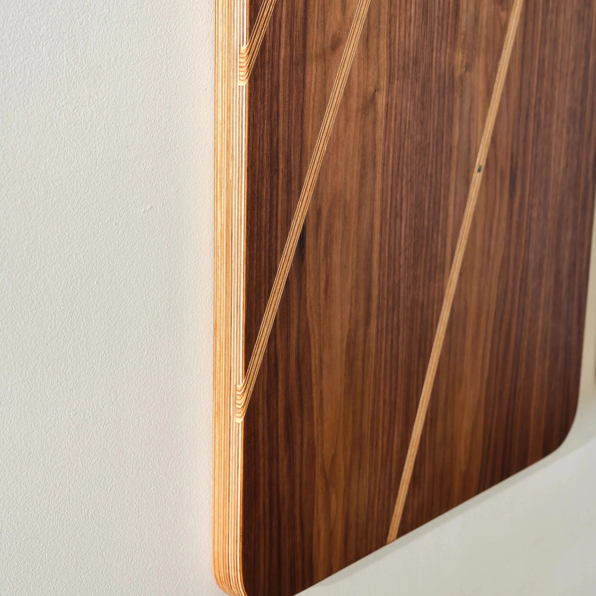 Angled closeup of Sunbeam walnut panel edge showing layered birch plywood stripes
