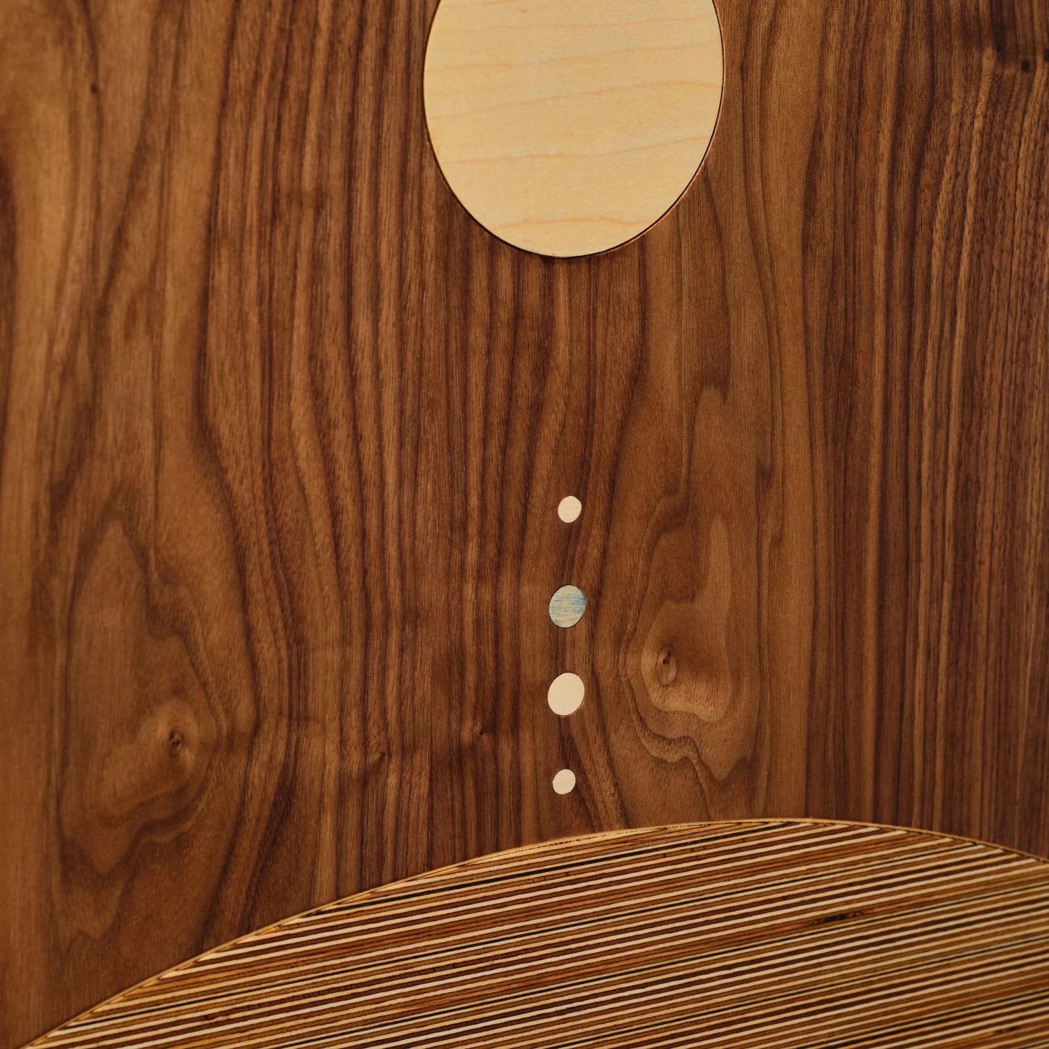 Closeup of System walnut art with maple circle and small dot inlays