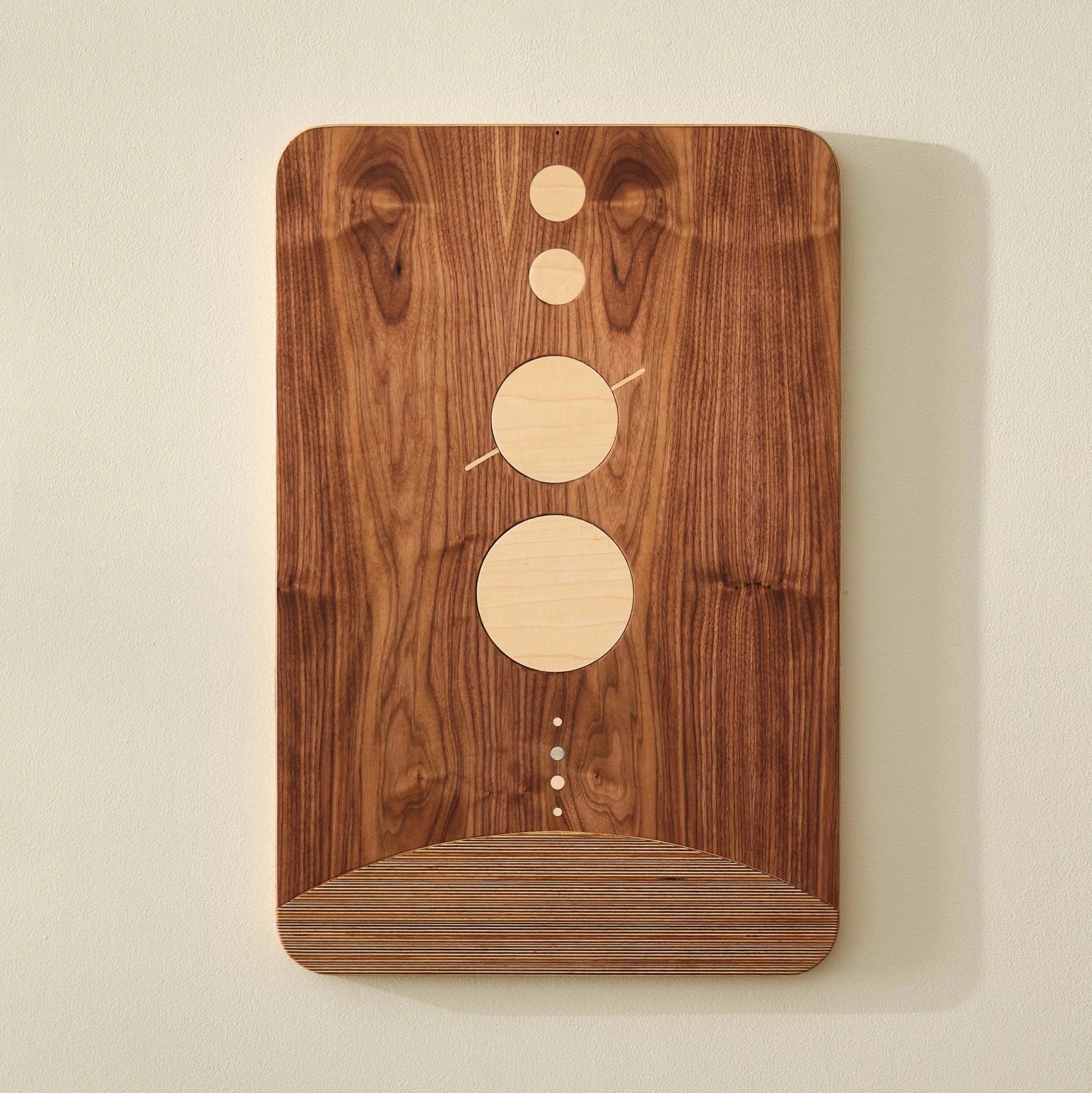 System walnut wall art with maple circles and layered birch curve, front view