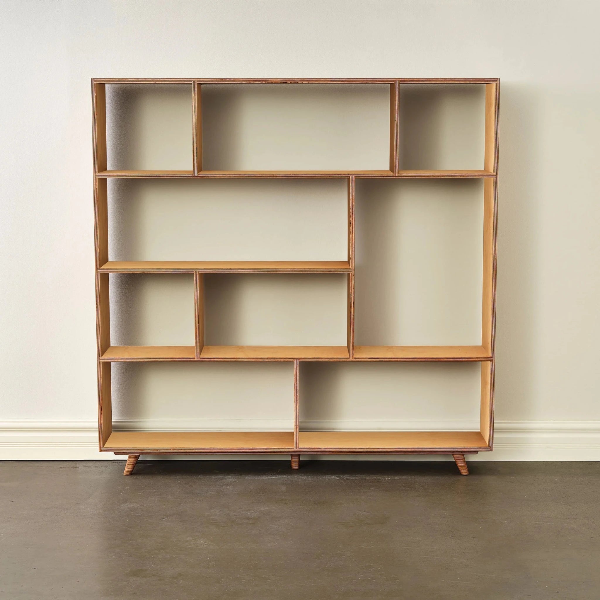 Empty maple bookcase, wider design, asymmetric shelves, light birch tone, front view