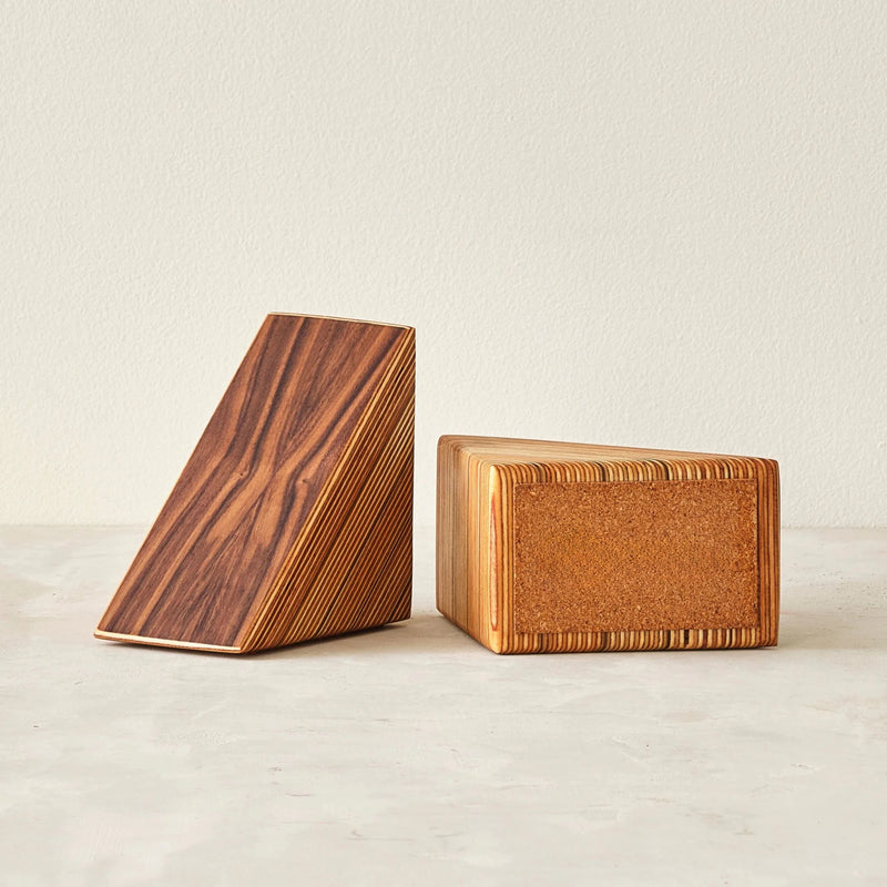 Pair of wedge walnut bookends, one showing cork base, layered birch edges, neutral background