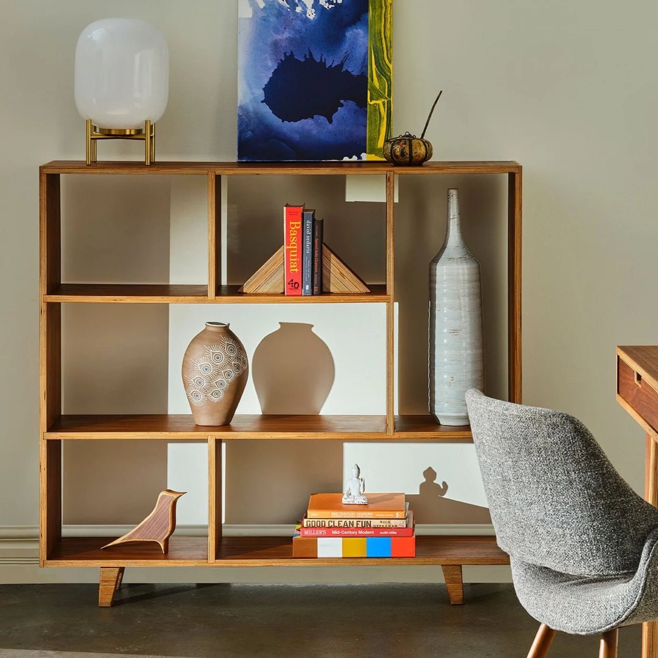 Styled birch plywood bookshelf with books, vases, lamp and small walnut Robin bird sculpture