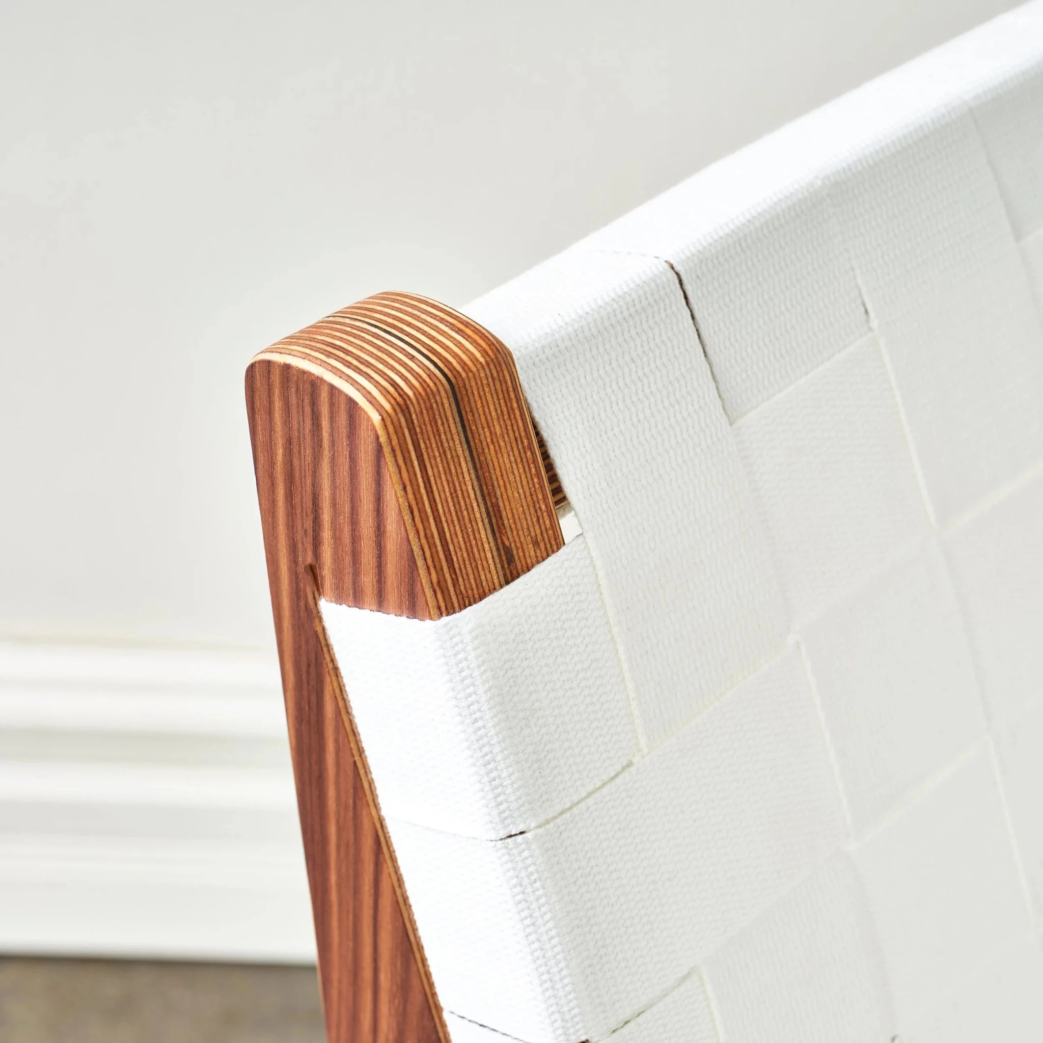 Rounded walnut backrest post cap with layered birch plywood and white woven webbing