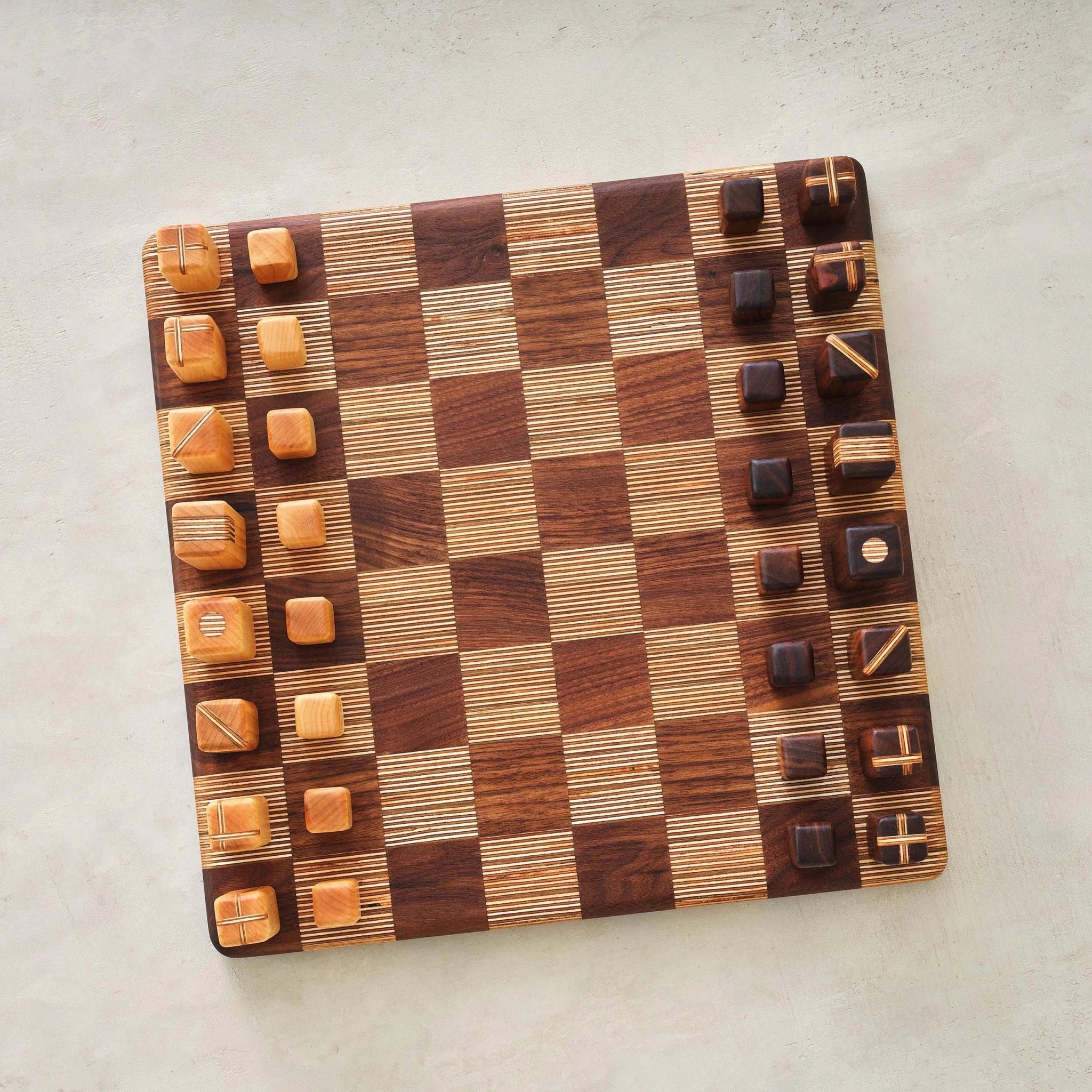 Overhead view of board with walnut and birch chess pieces marked with symbols