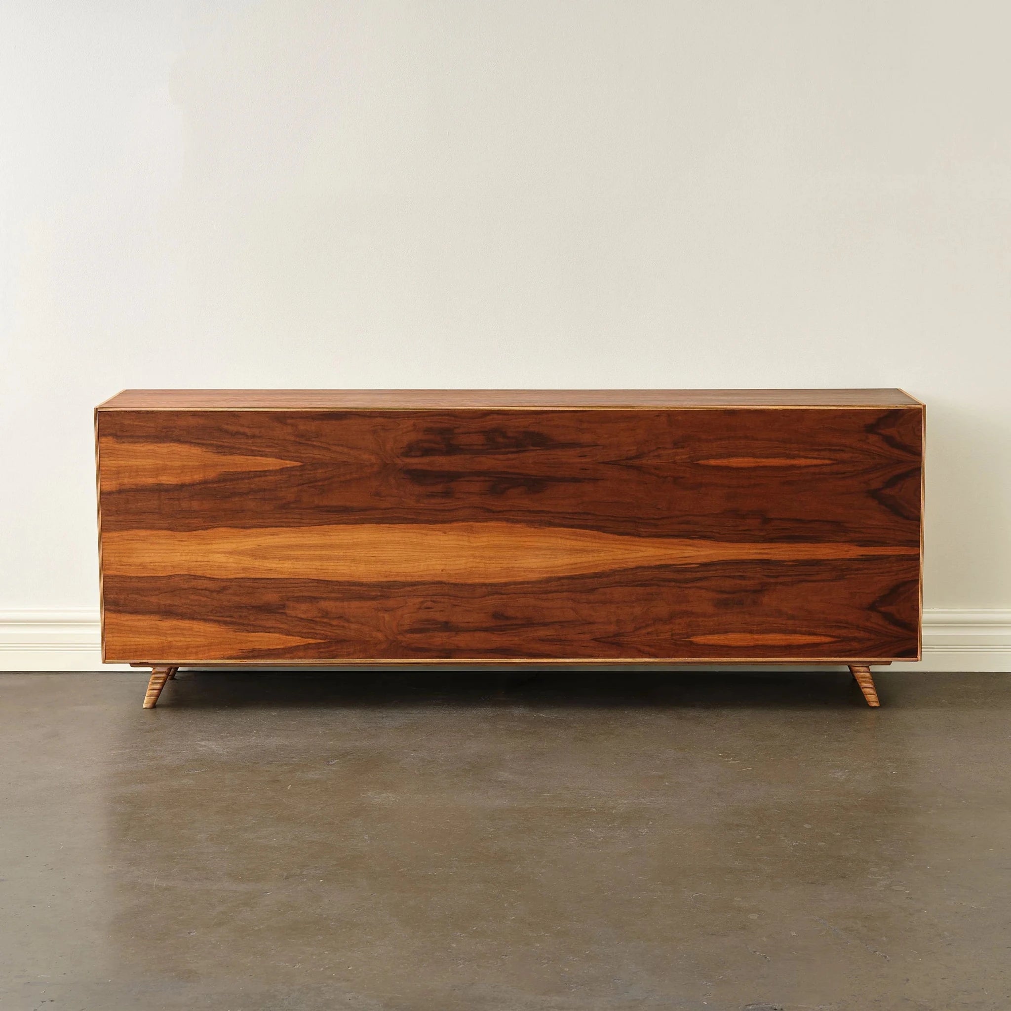 Rear view of walnut sideboard showing bookmatched grain panel on tapered legs
