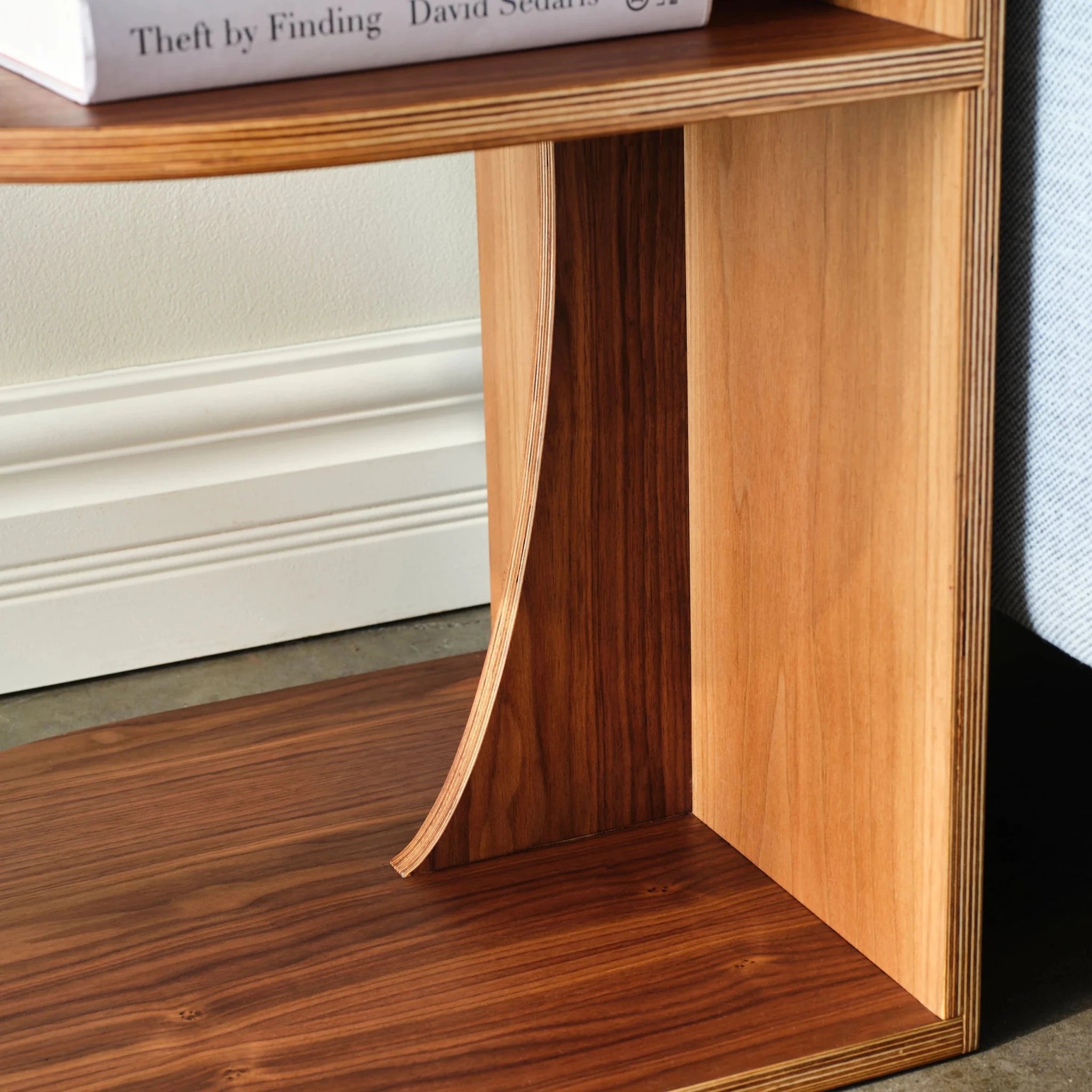 Walnut End Table No. 2 close-up, curved layered birch plywood joinery edge, books above