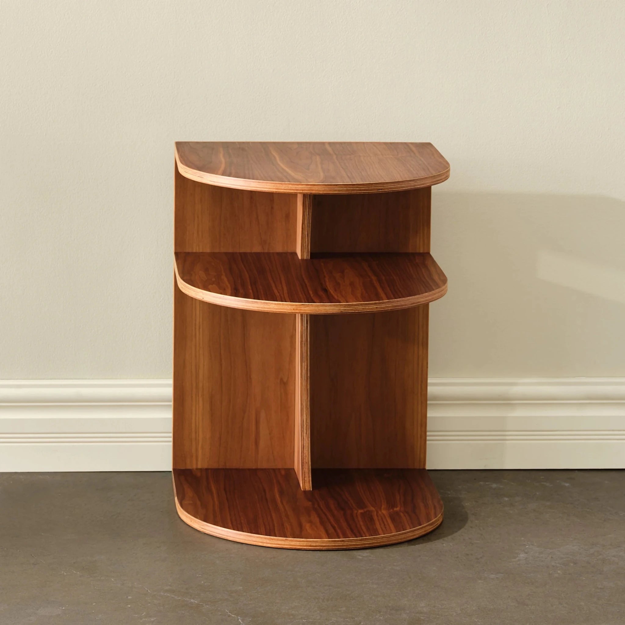 Walnut End Table No. 2 front view, curved two-tier open shelves, empty, cream wall