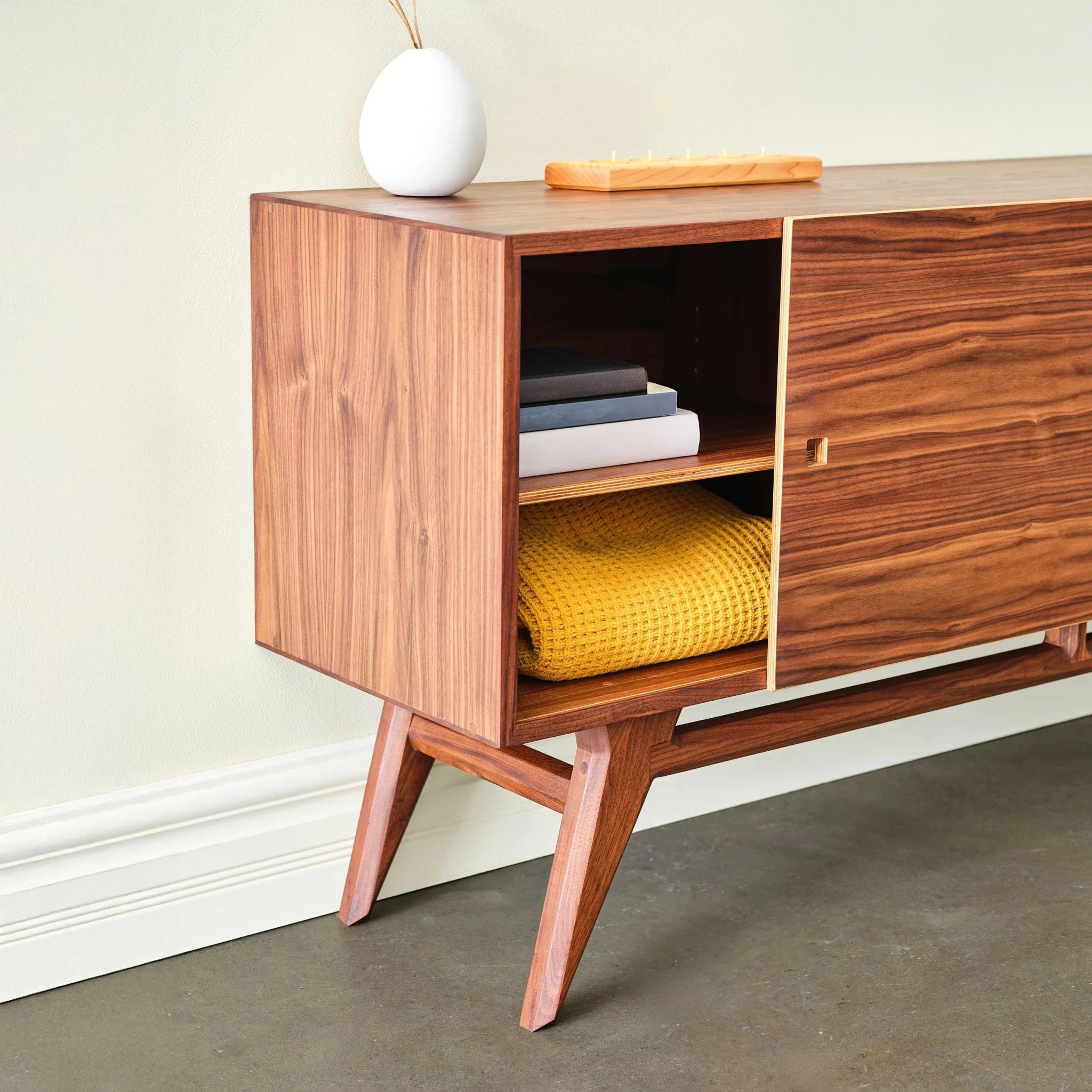Walnut Media Console No. 2 open cabinet showing stacked books and folded yellow blanket inside