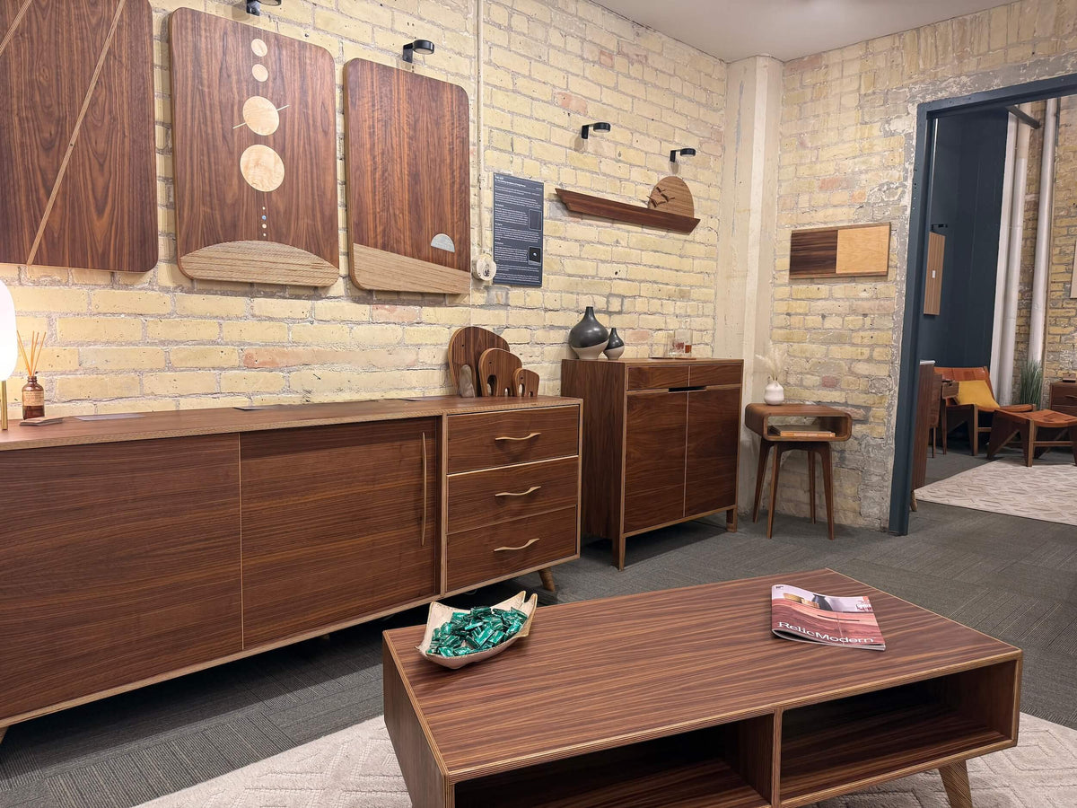 Wooden furniture including cabinets and a coffee table in a room with brick walls.