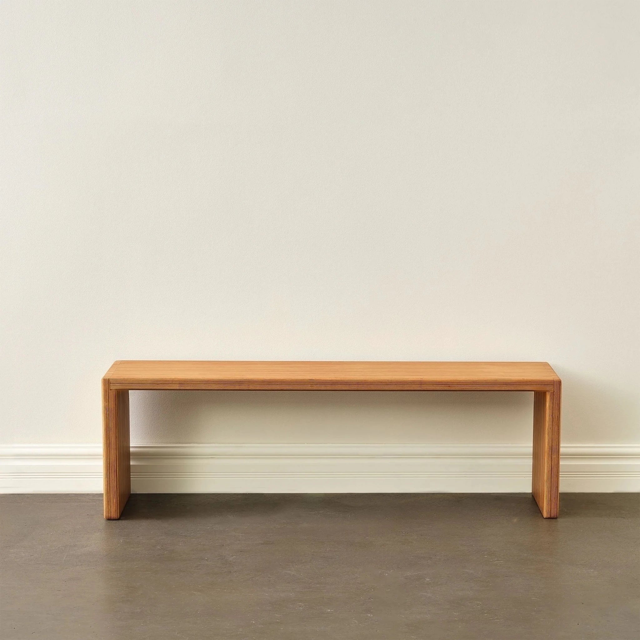 Longer 60-inch Baltic birch bench, front view, waterfall legs, empty against pale wall