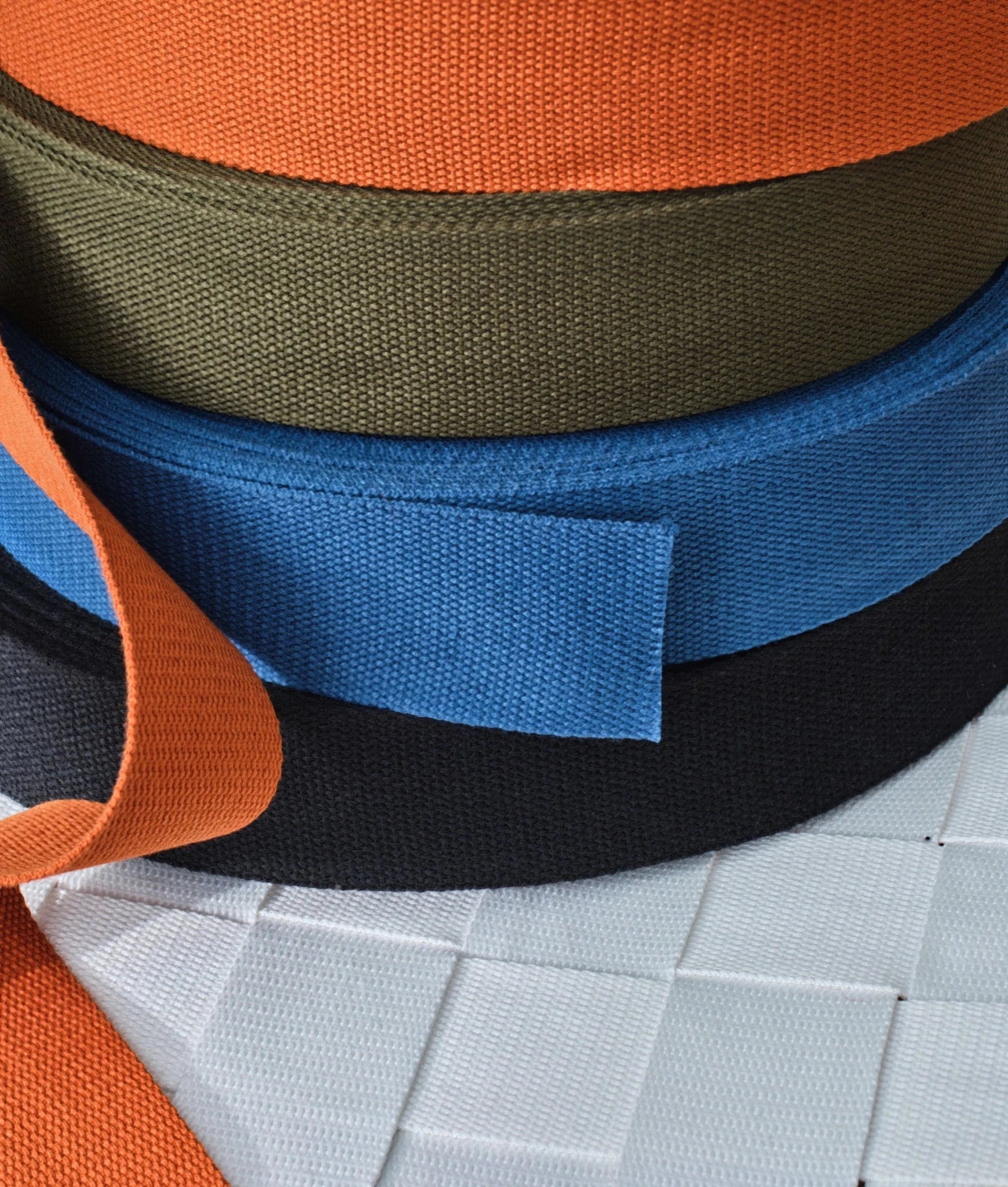 Chair strap fabric samples: orange, olive, blue, black webbing plus white leather