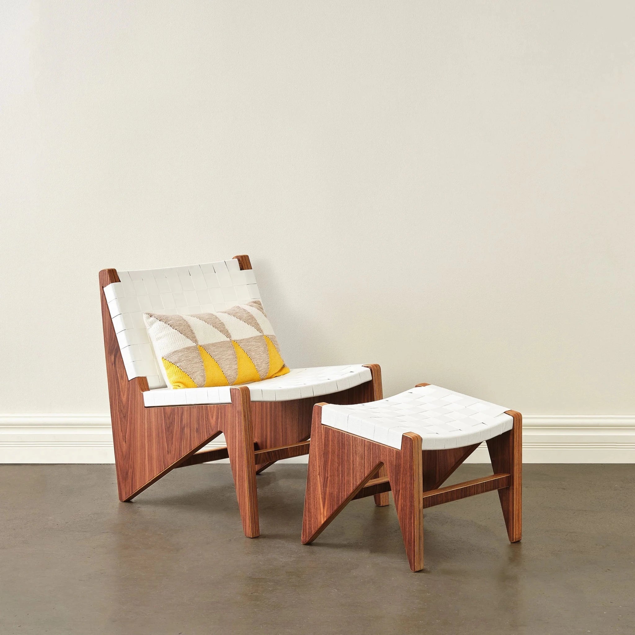 Walnut accent chair with white woven seat, yellow accent pillow, and matching ottoman