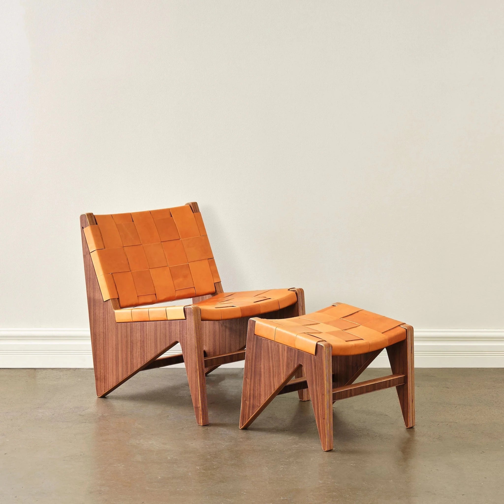 Walnut lounge chair and ottoman with tan woven leather straps, front view