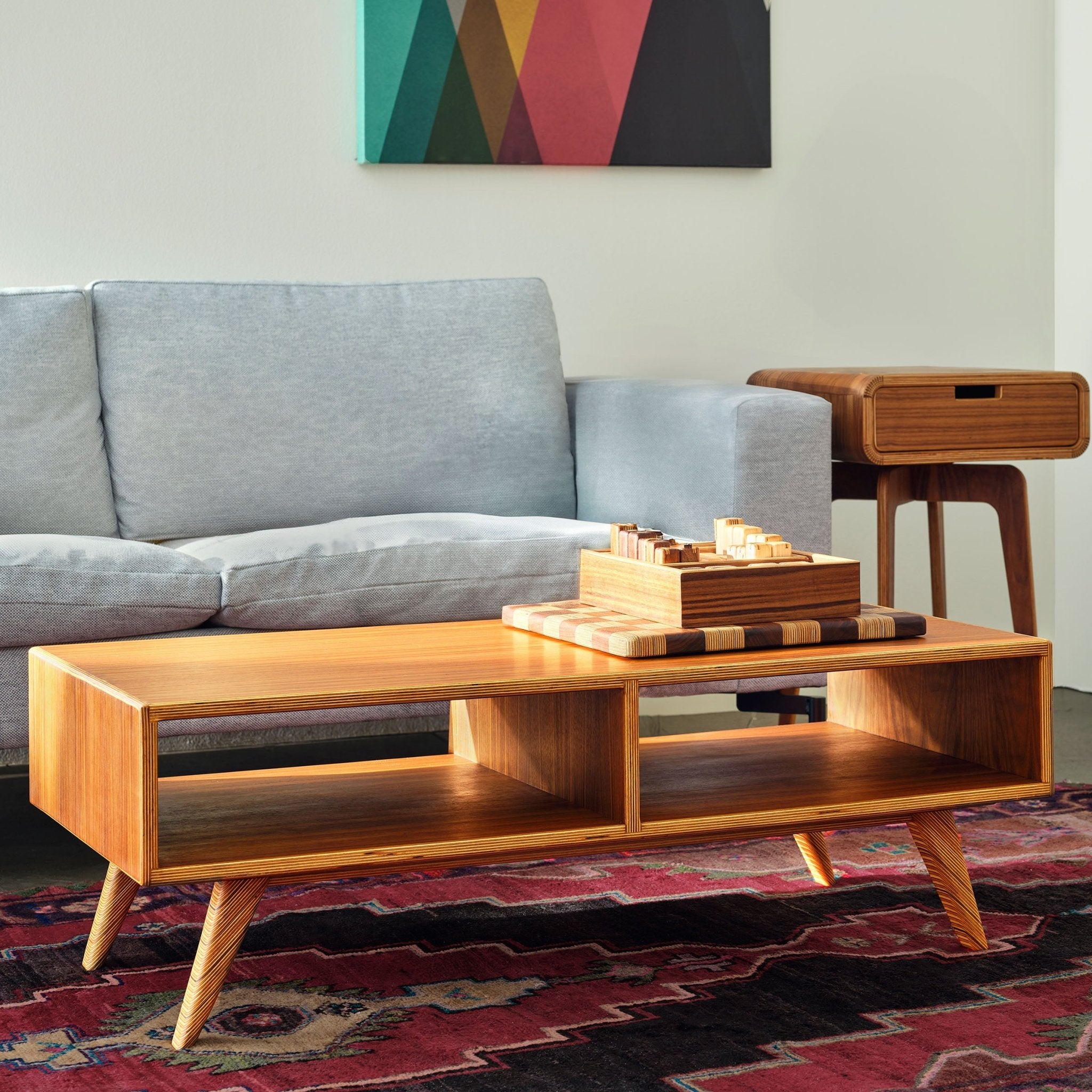 Walnut Coffee Table angled view, open shelf, wooden tray, gray sofa, patterned rug