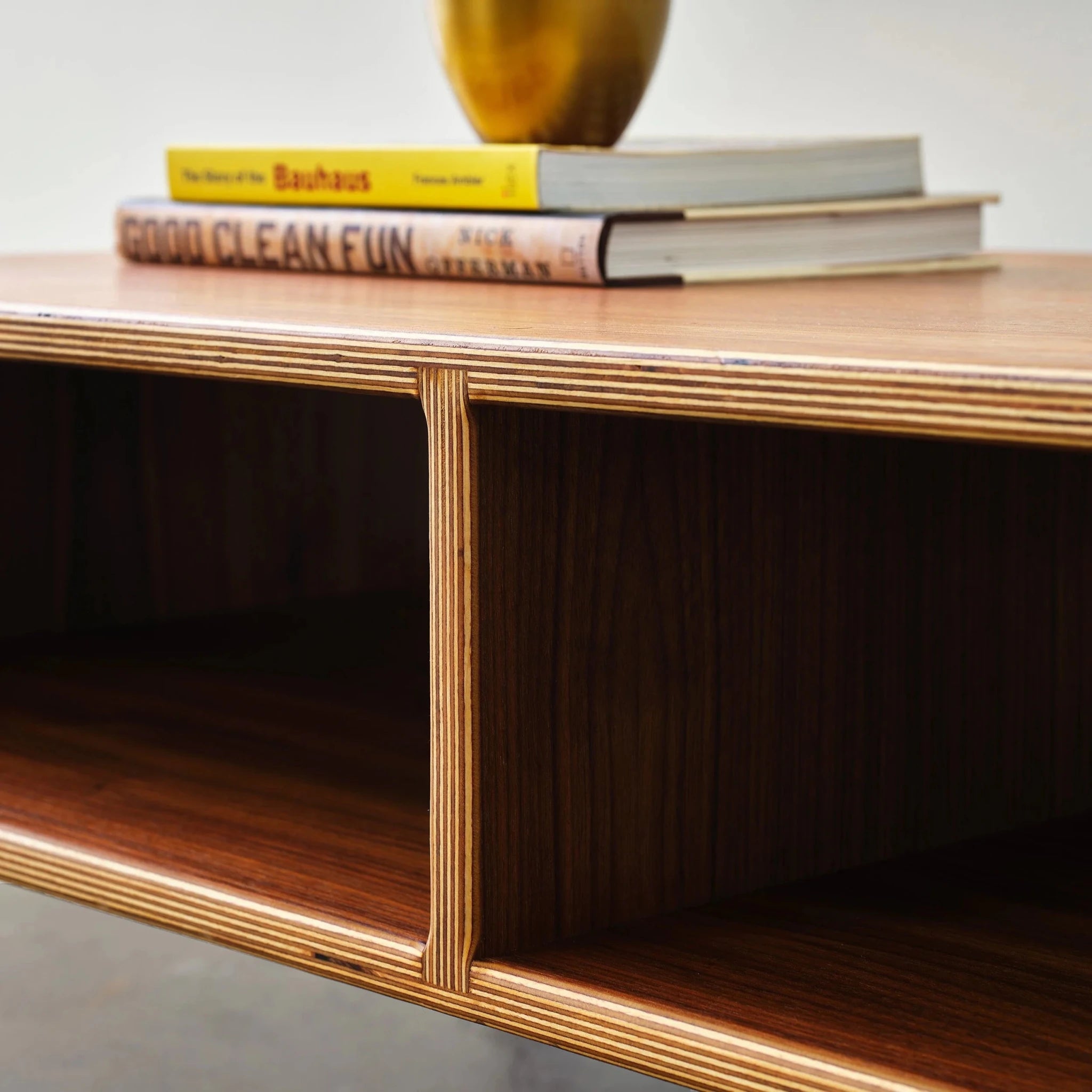 Walnut Coffee Table close-up, layered birch plywood edge joinery, open compartment, books