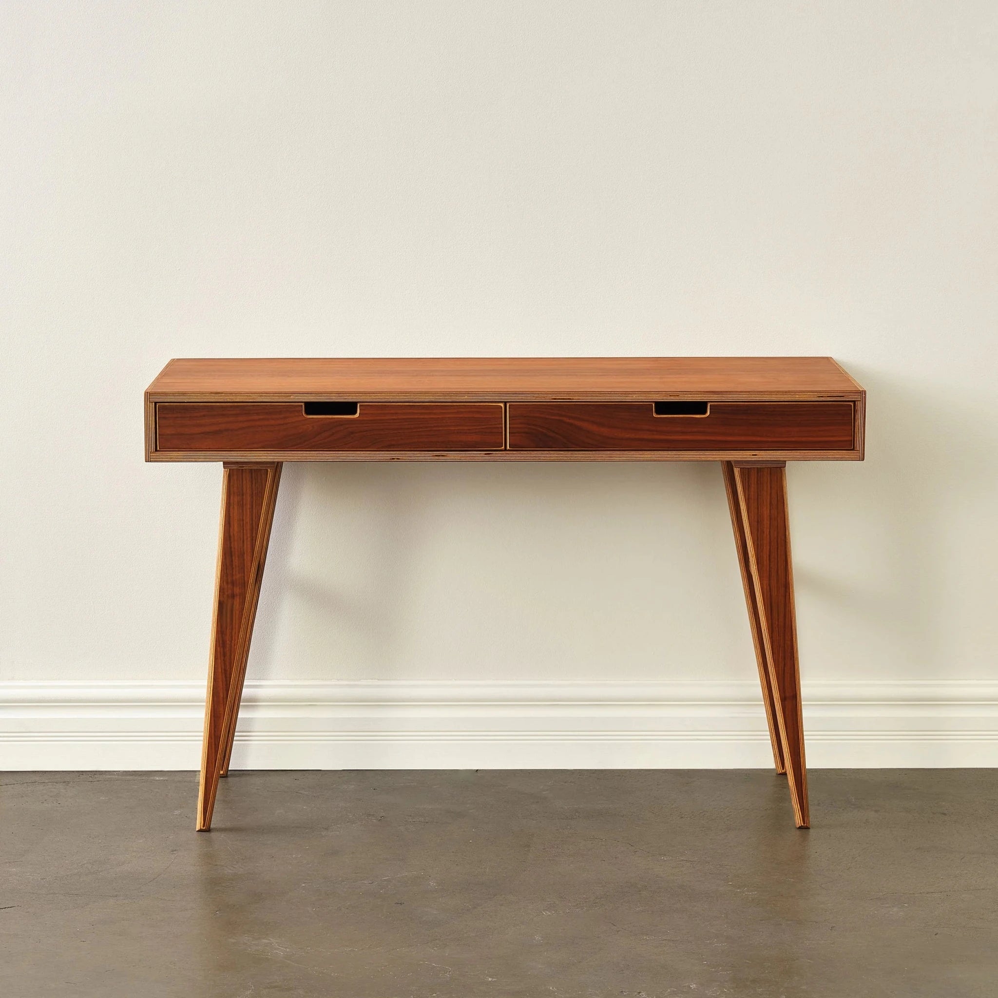 Front view of walnut writing desk with two drawers and tapered legs