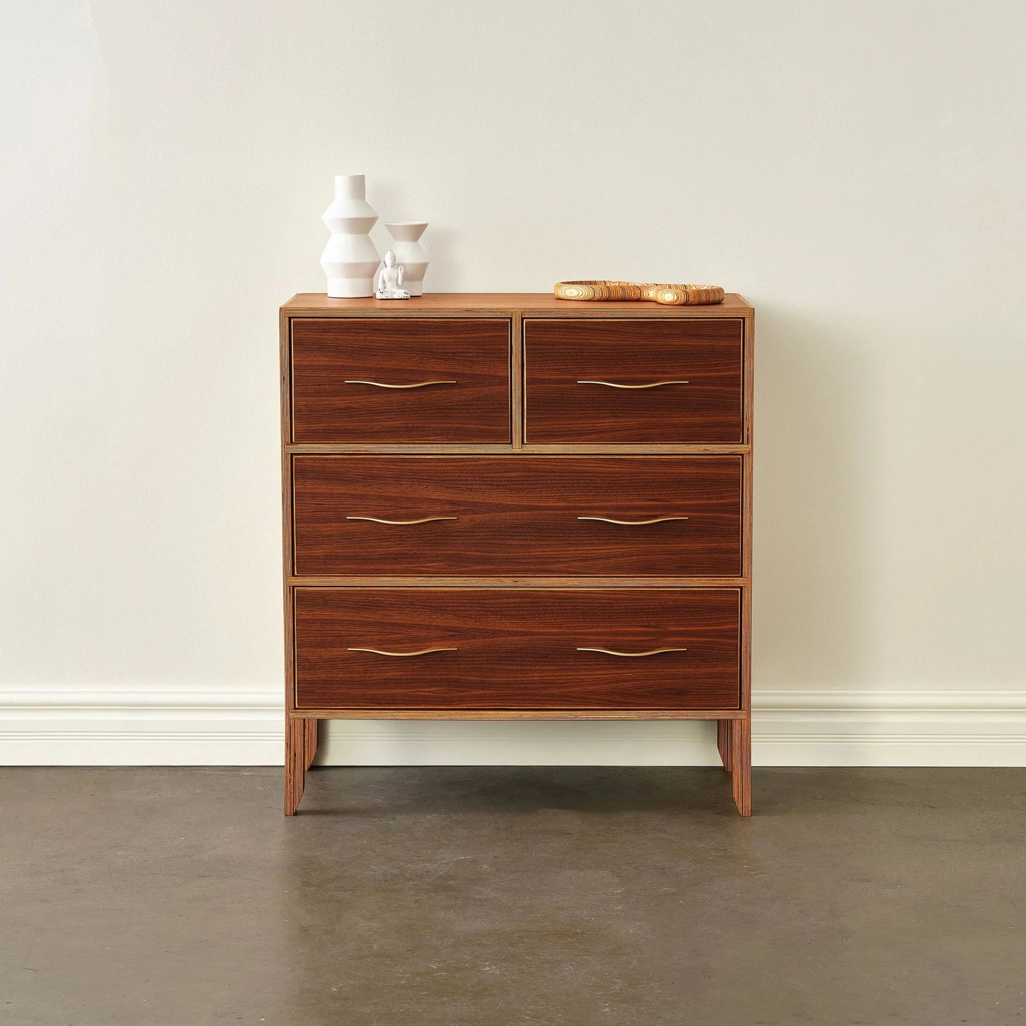 Walnut dresser front view, white vases and wooden tray on top, closed drawers