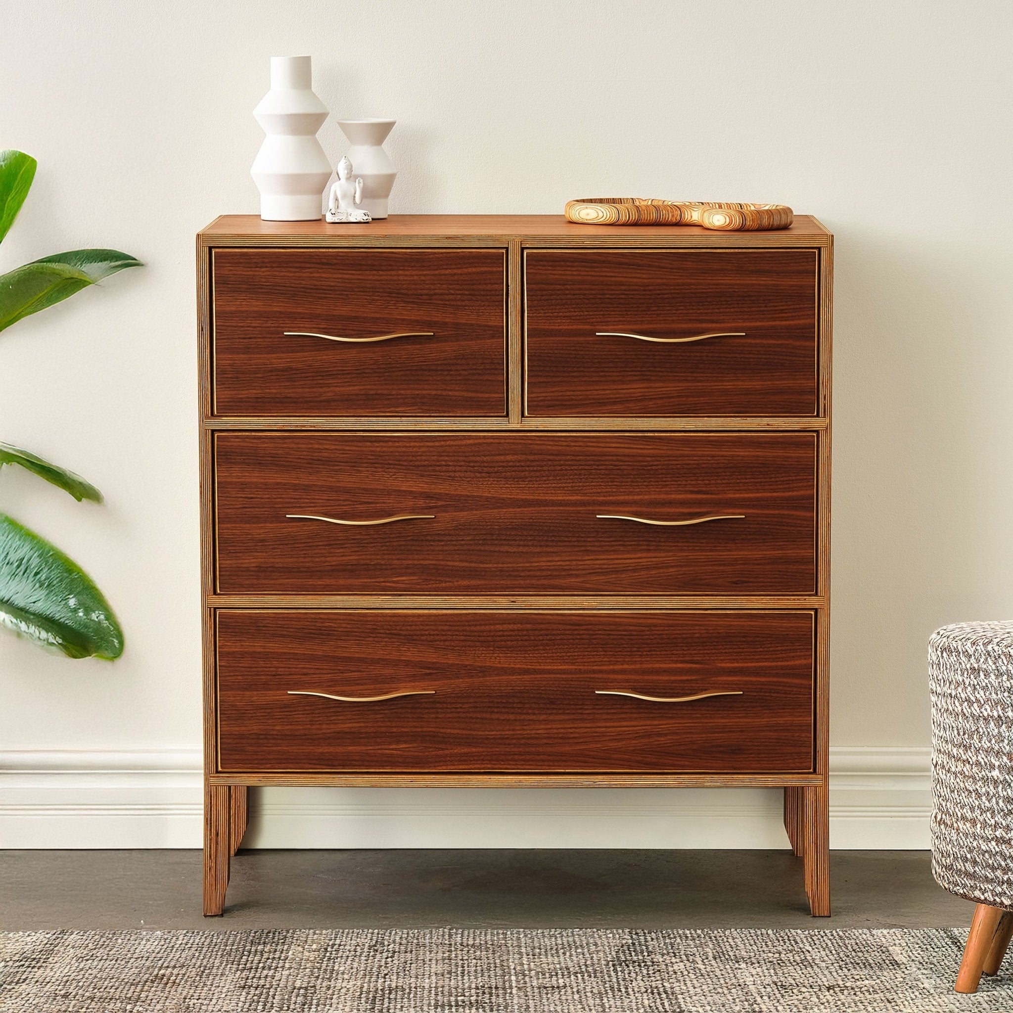 Walnut dresser front staged with white vases and wood tray, plant beside, closed drawers