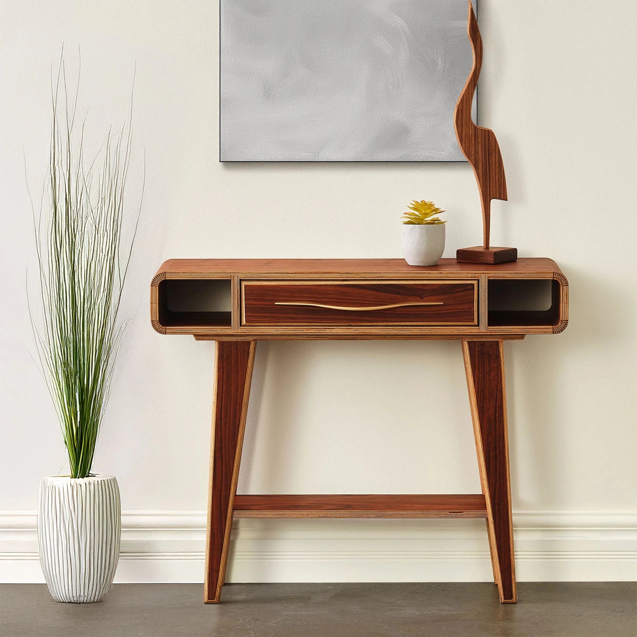 Walnut entry table styled with succulent, sculpture and plant, open side cubbies, brass drawer pull