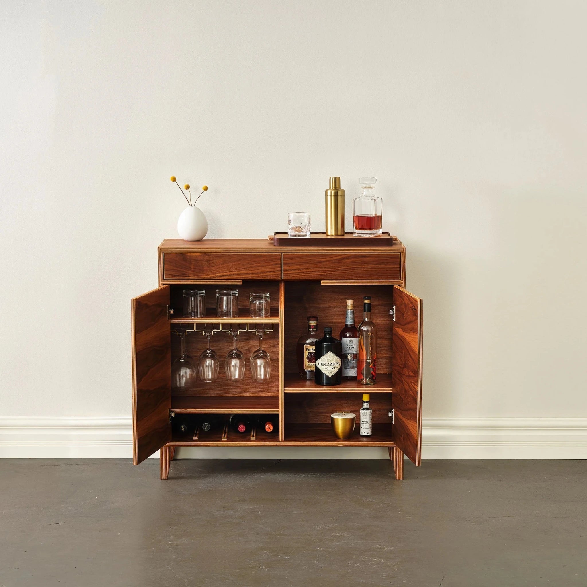 Walnut liquor cabinet with both doors open, revealing glassware, wine rack, and bottles