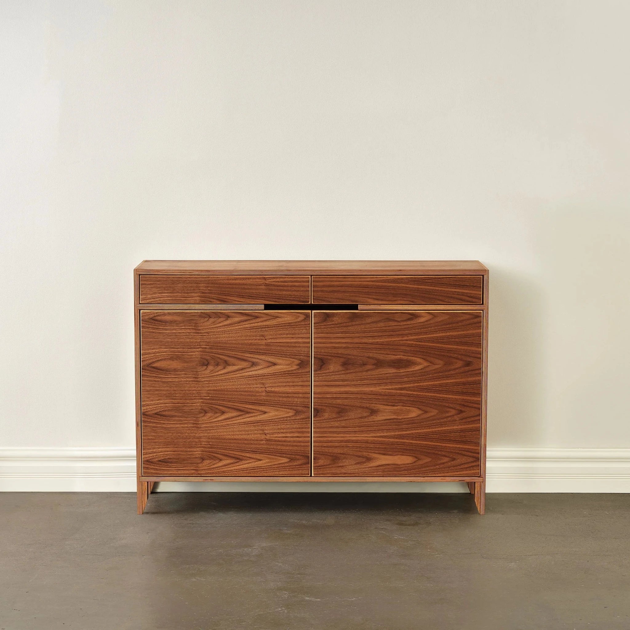 Wide 48-inch walnut liquor cabinet, front view, closed doors, plain background