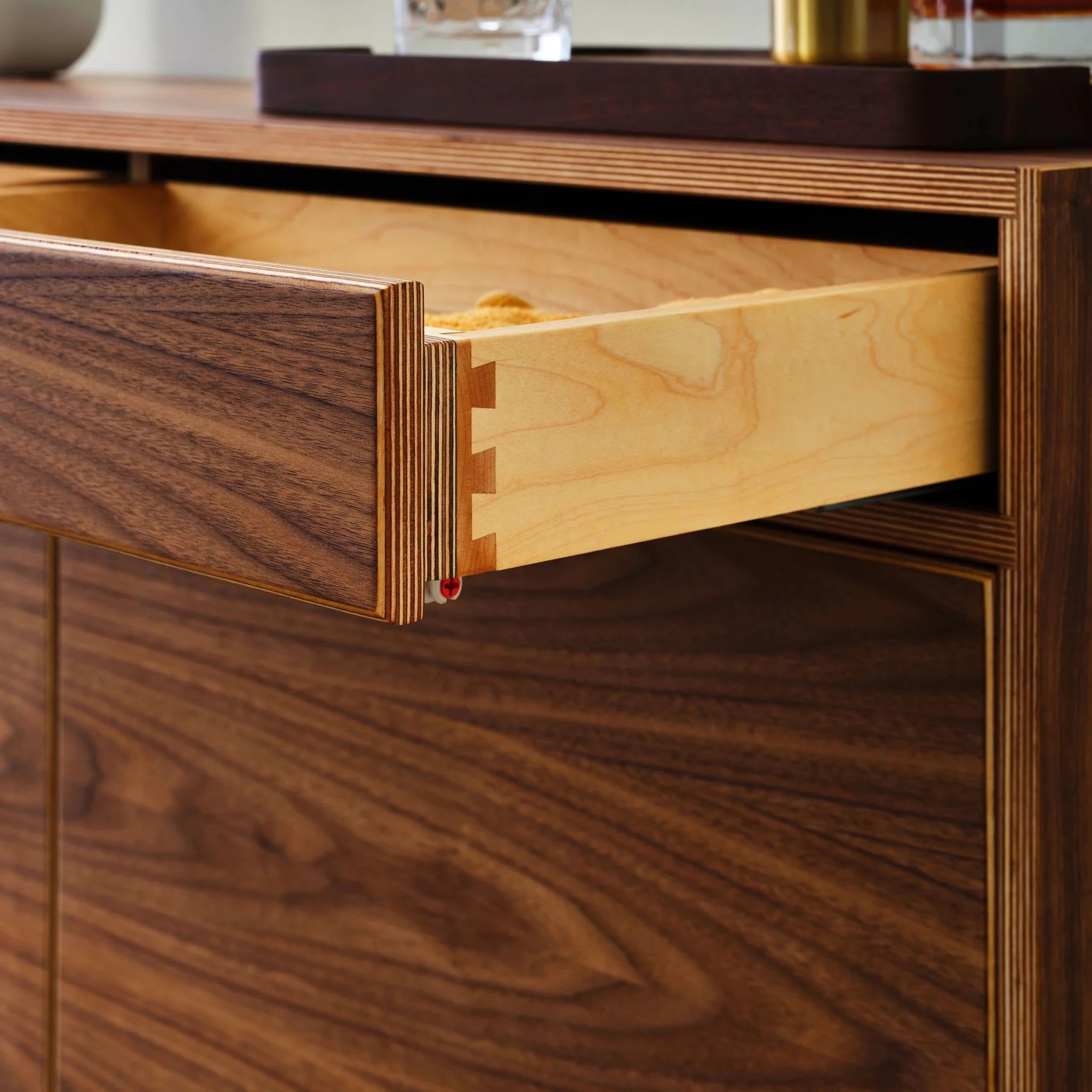 Open drawer detail showing birch dovetail joinery and walnut front