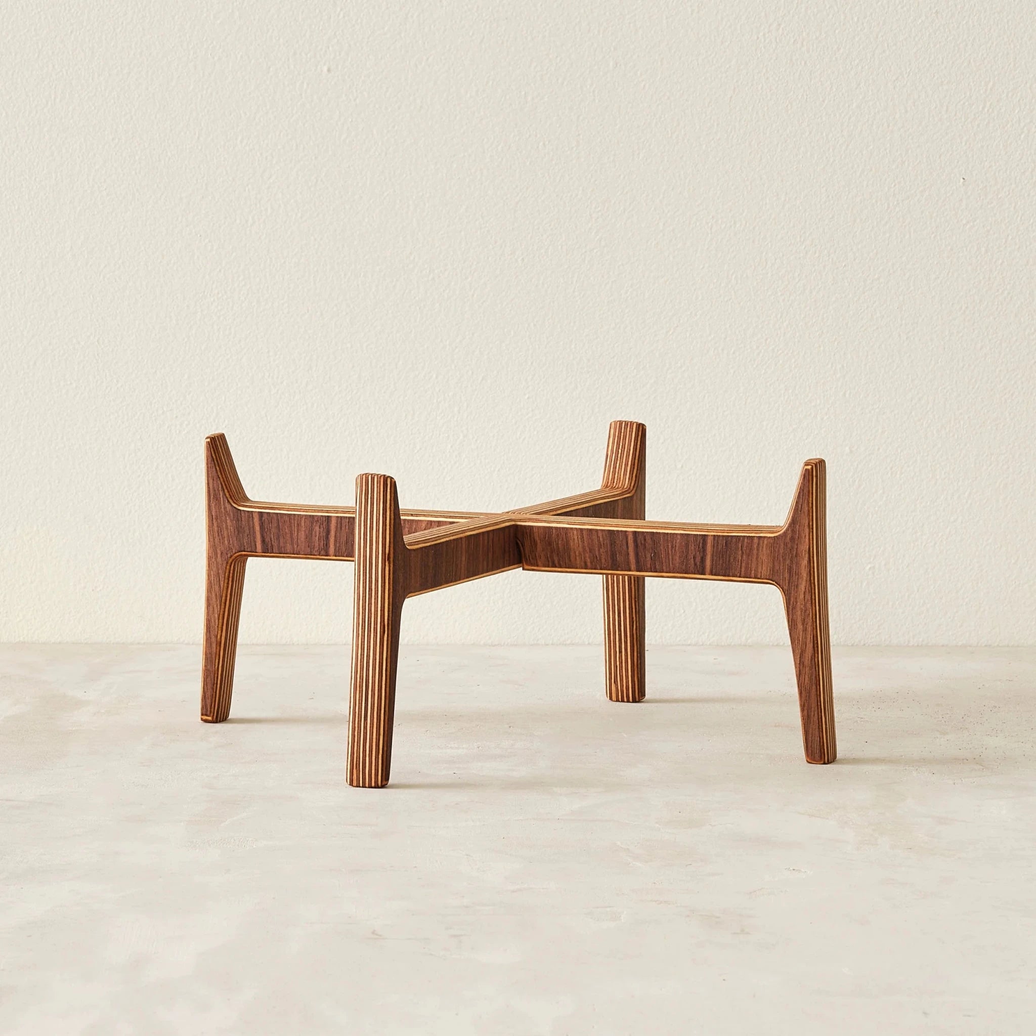 Empty wide walnut plant stand with layered birch plywood legs and crossed supports