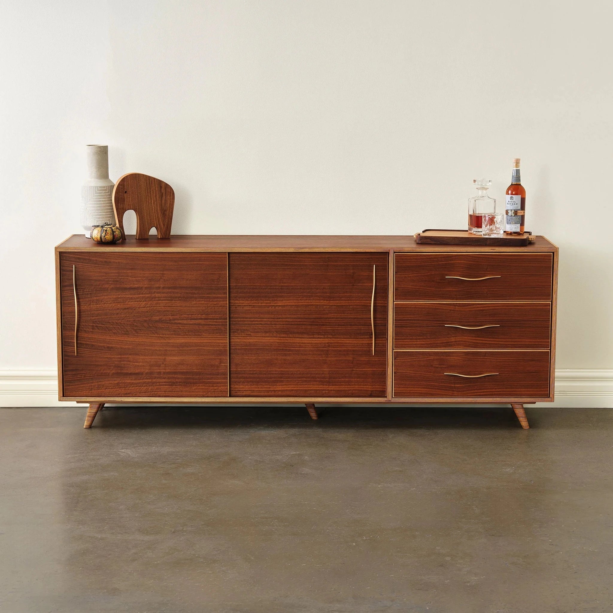 Walnut sideboard, closed doors and drawers, topped with walnut elephant, vase, whiskey decanter