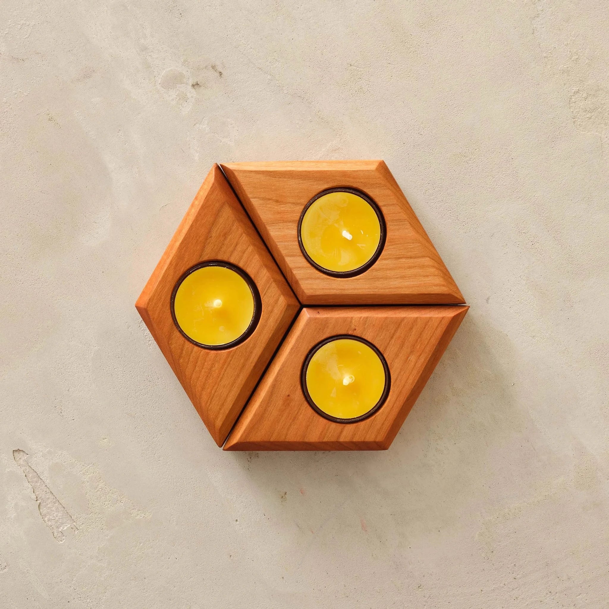 Three cherry diamond tealight holders forming hexagon, three yellow candles, top view
