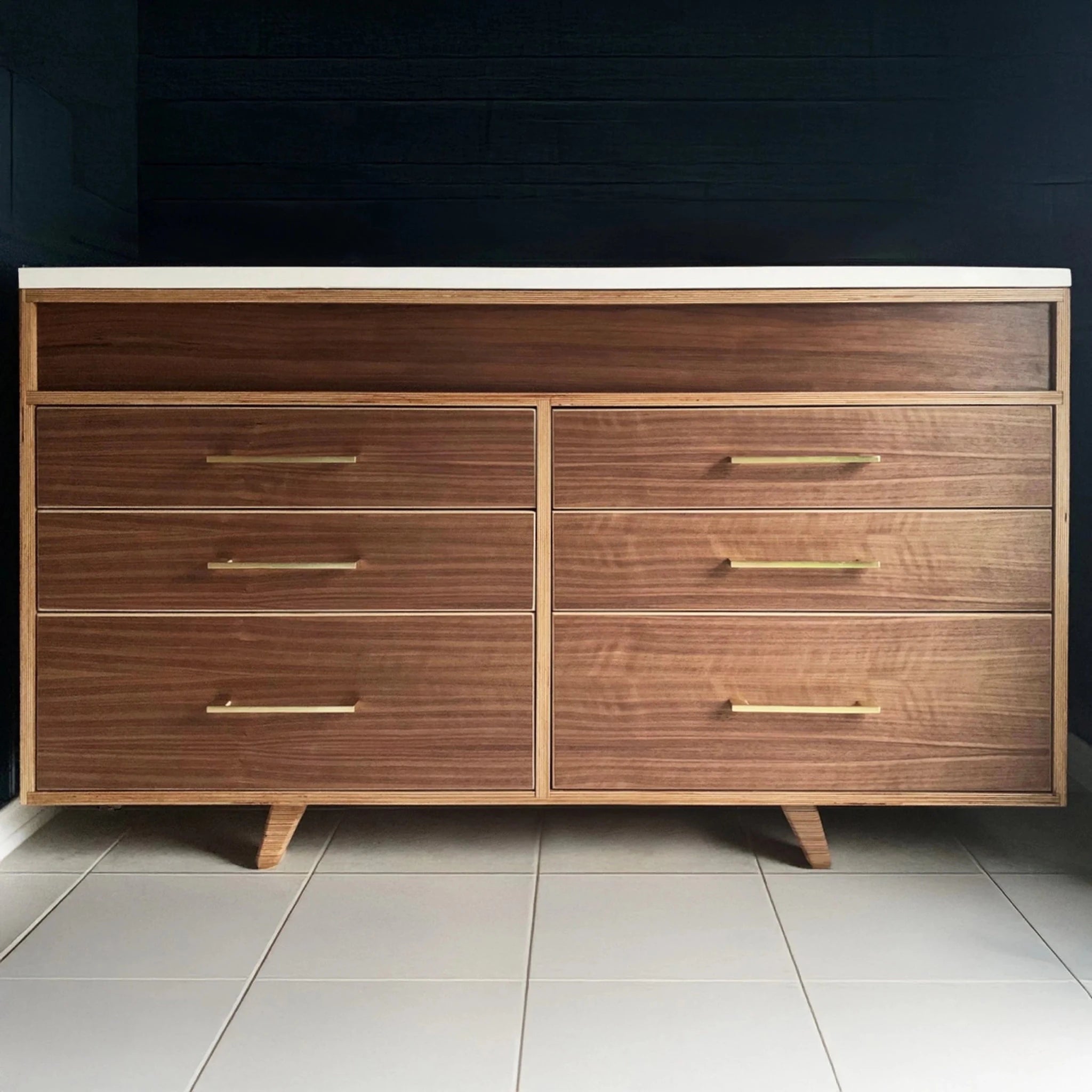 Front view walnut double vanity, six drawers, brass pulls, white top, splayed legs